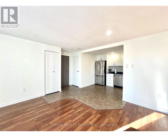 A kitchen with white walls and wooden floors.