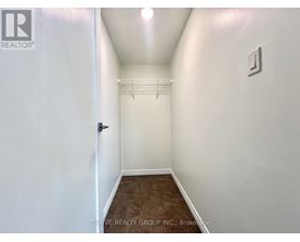 A hallway with a door on the left and a light switch on the wall.