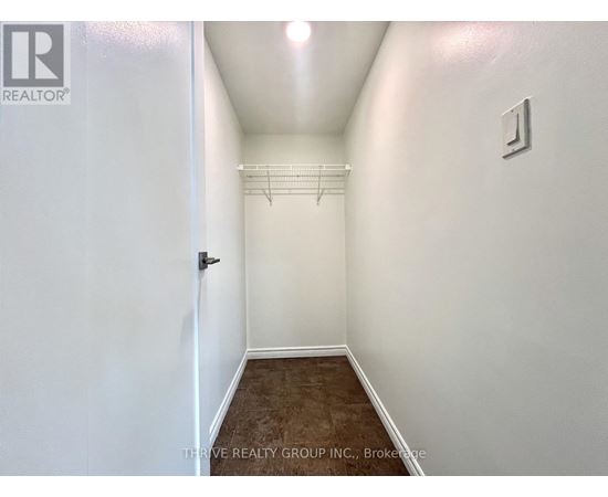 A hallway with a door on the left and a light switch on the wall.