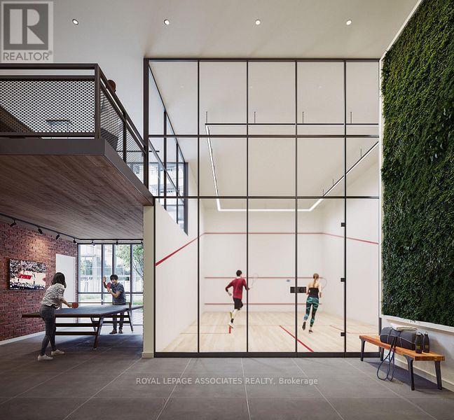 A man and a woman are playing squash in a room with a green wall on the side.