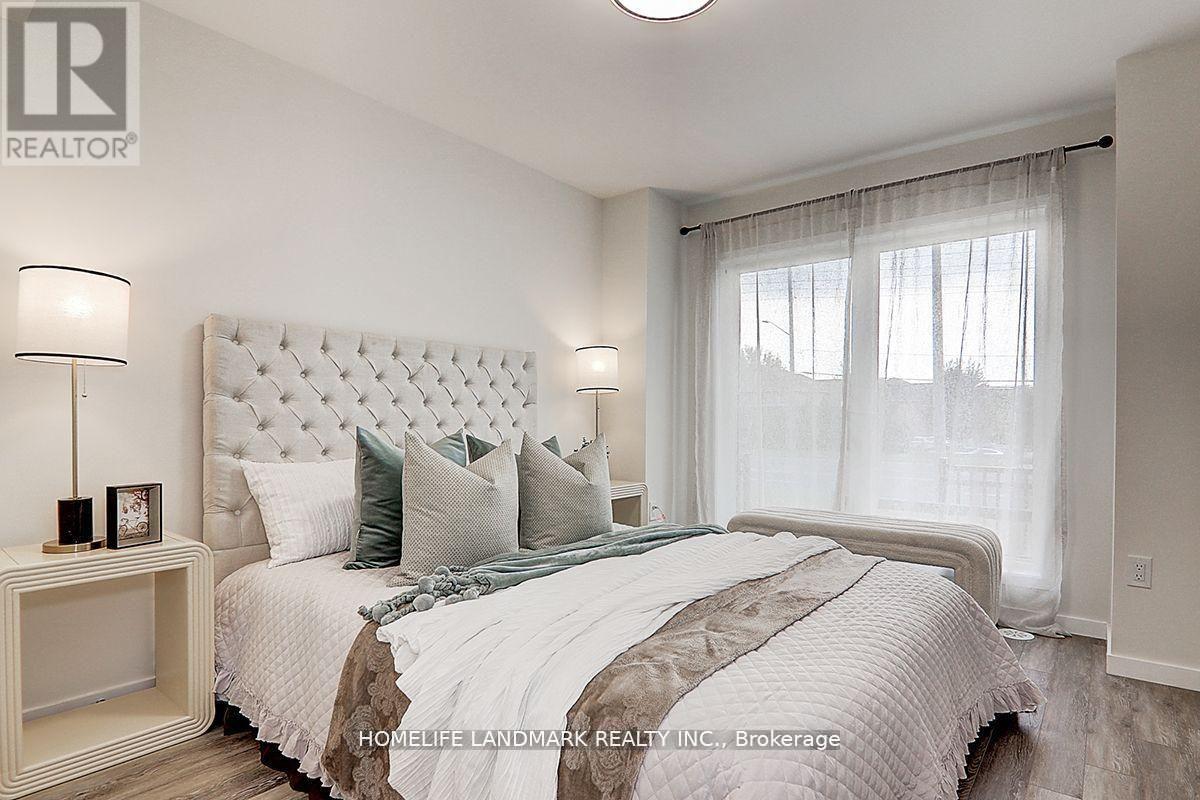 A bedroom with a large bed and a nightstand with a lamp.