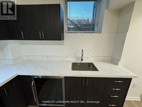 A kitchen with black cabinets and a marble countertop.