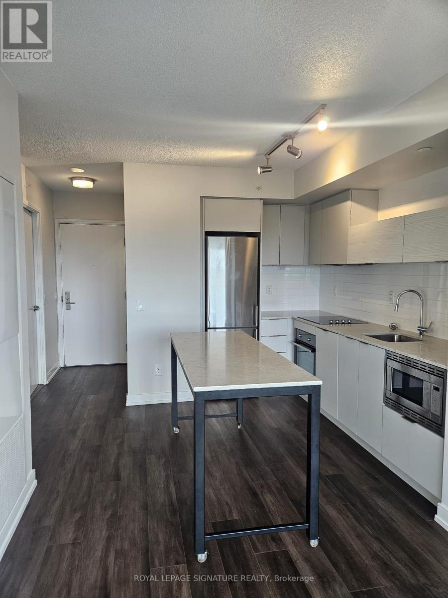 A kitchen with white cabinets and a wooden table.