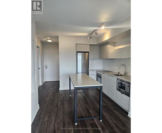 A kitchen with white cabinets and a wooden table.
