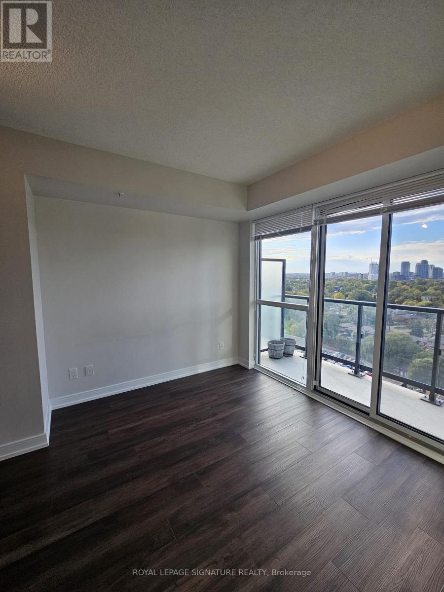 A room with wooden floors and a view of the city through the windows.