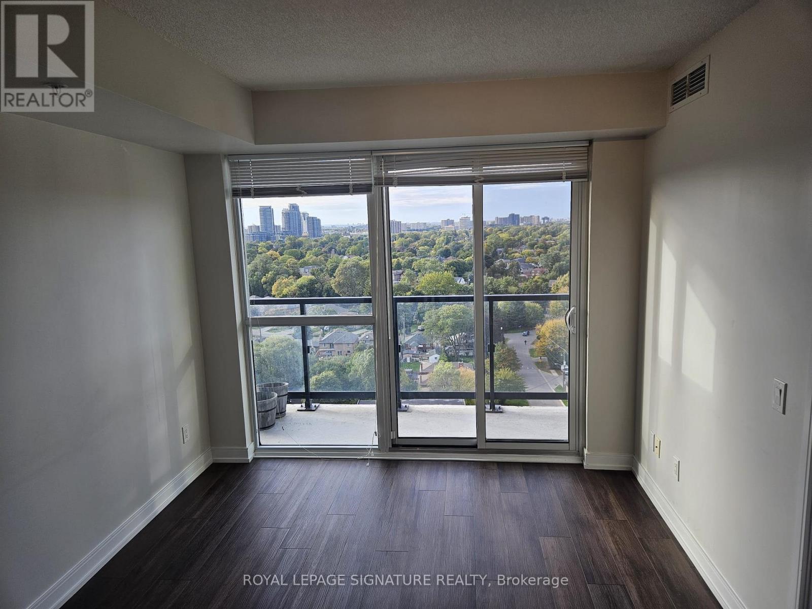 A room with a view of the city through large windows.