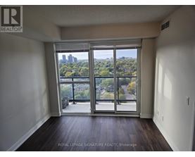 A room with a view of the city through large windows.