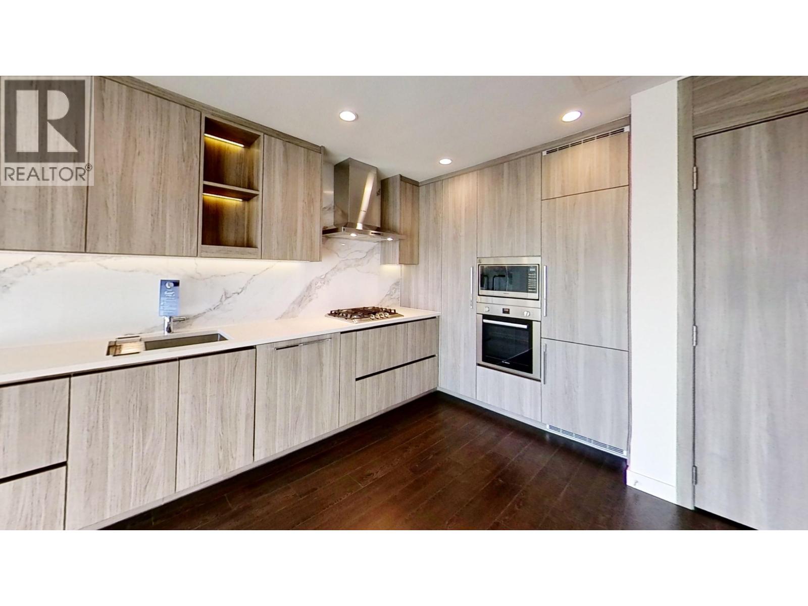 A modern kitchen with wooden cabinets and a marble countertop.
