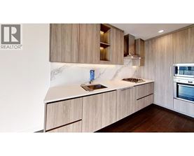A modern kitchen with wooden cabinets and a marble countertop.