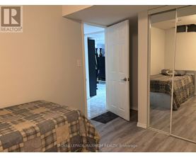 A bedroom with a bed and a mirrored closet door.