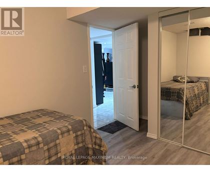A bedroom with a bed and a mirrored closet door.