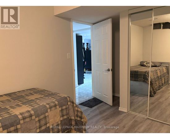 A bedroom with a bed and a mirrored closet door.