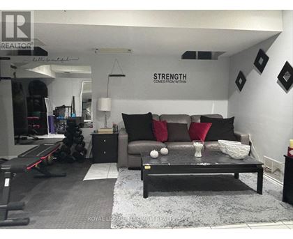 A living room with a grey couch and a black coffee table.