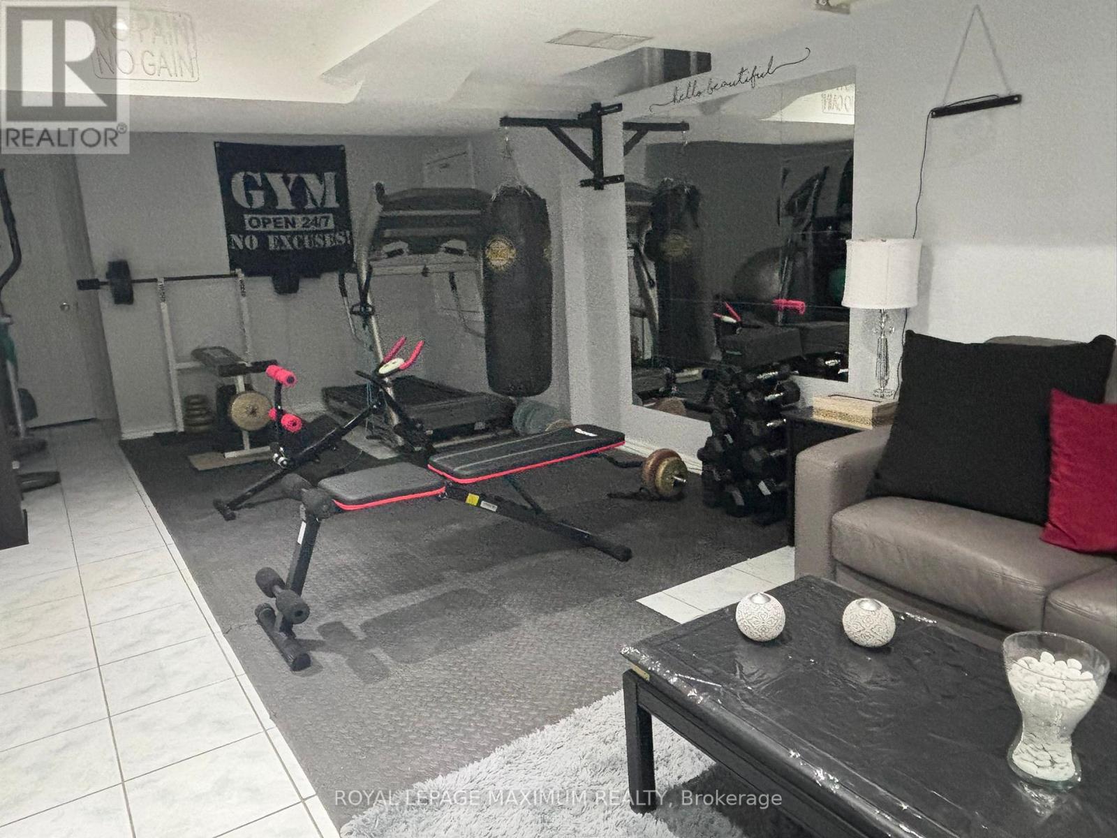A gym room with a treadmill, weights, and exercise equipment.