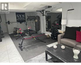 A gym room with a treadmill, weights, and exercise equipment.
