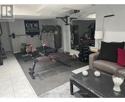 A gym room with a treadmill, weights, and exercise equipment.