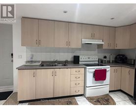 A kitchen with wooden cabinets and a white stove top oven.
