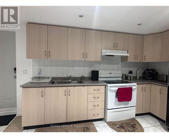 A kitchen with wooden cabinets and a white stove top oven.