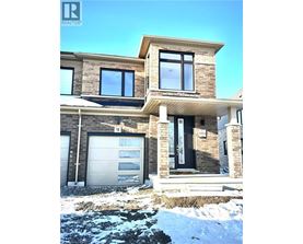 A modern house with a garage and a stone wall.