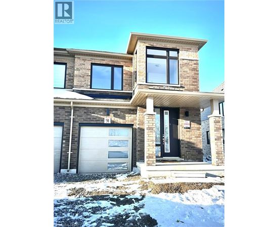 A modern house with a garage and a stone wall.