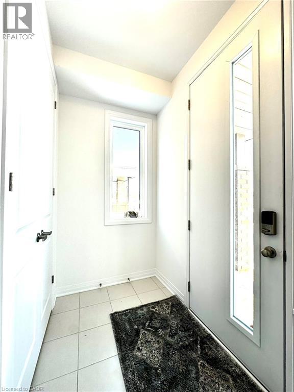 A hallway with a black and white rug and white doors.