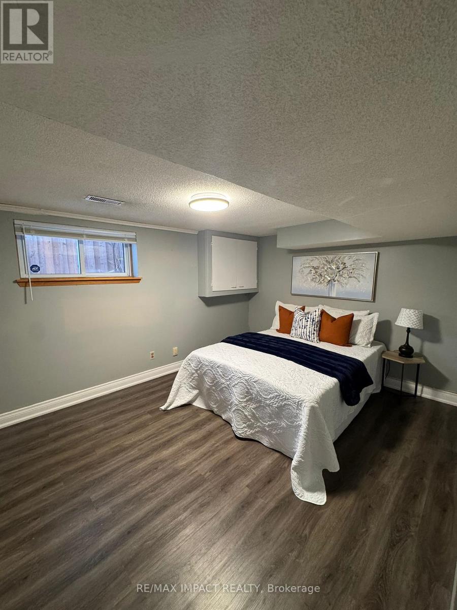 A bedroom with a bed, nightstand, and window.