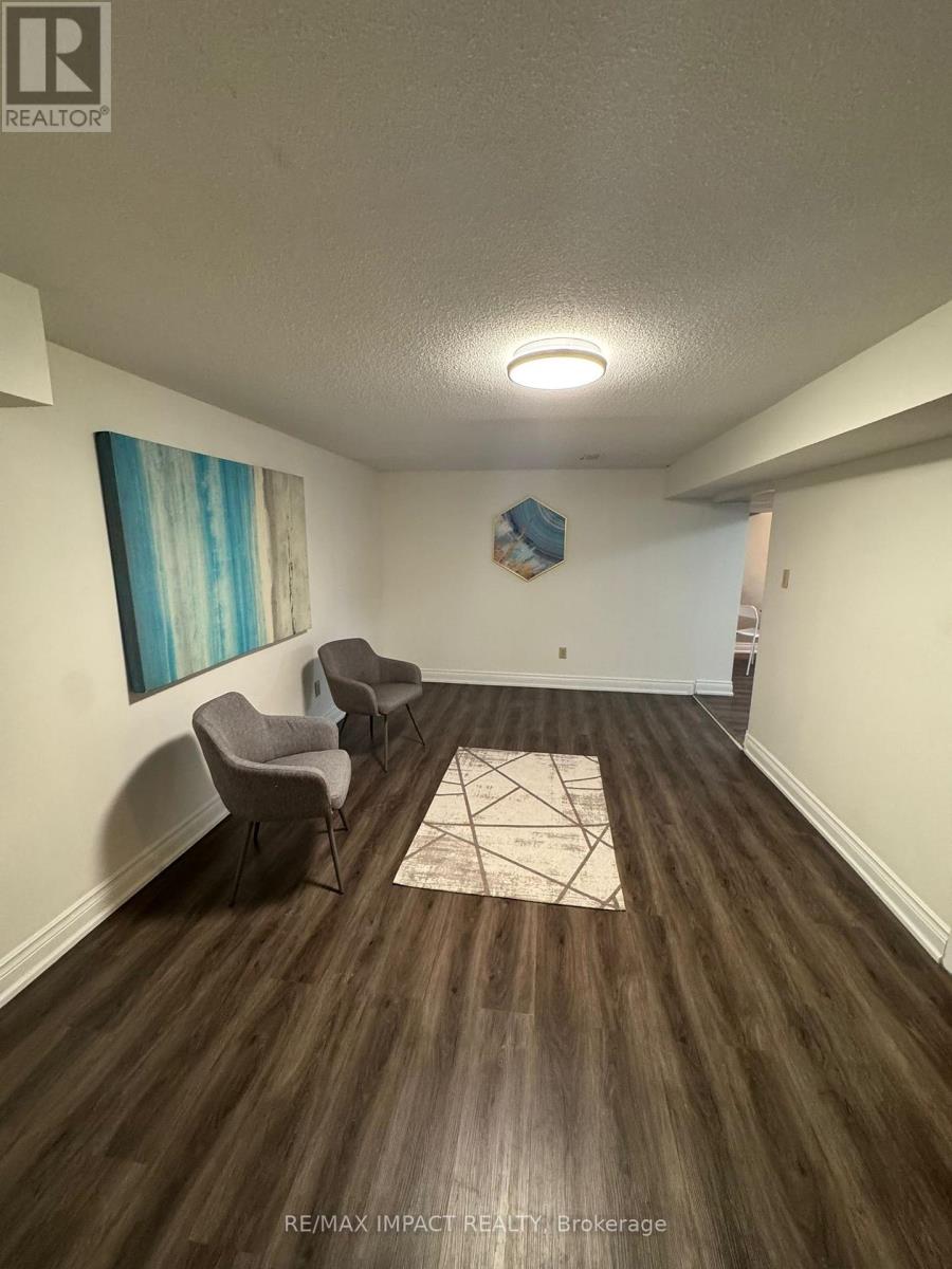 A room with wood flooring and a painting on the wall.