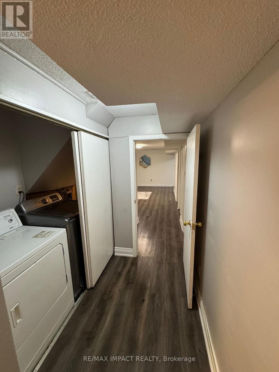 A hallway with a washer and dryer in the laundry room.