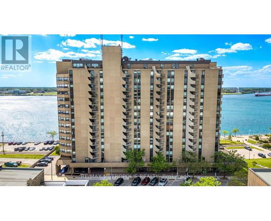 A tall residential building with a parking lot in front.