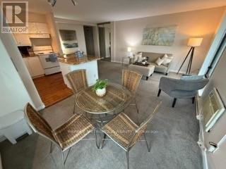 A dining room with a glass table surrounded by chairs.