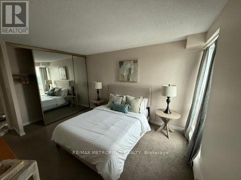 A bedroom with a large bed and a mirror on the wall.