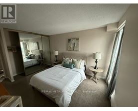 A bedroom with a large bed and a mirror on the wall.