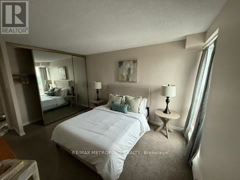 A bedroom with a large bed and a mirror on the wall.