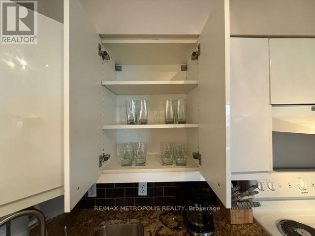 A kitchen with white cabinets and a sink.