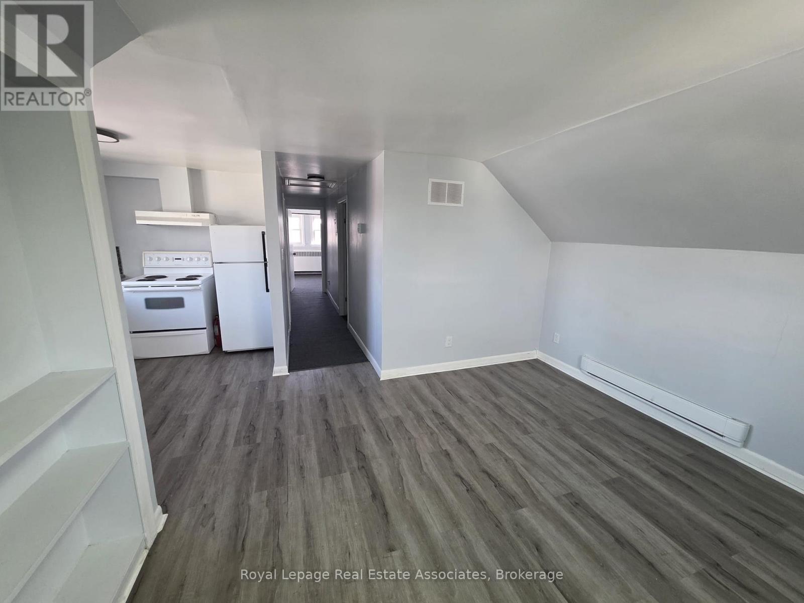 A room with wooden flooring and white walls.