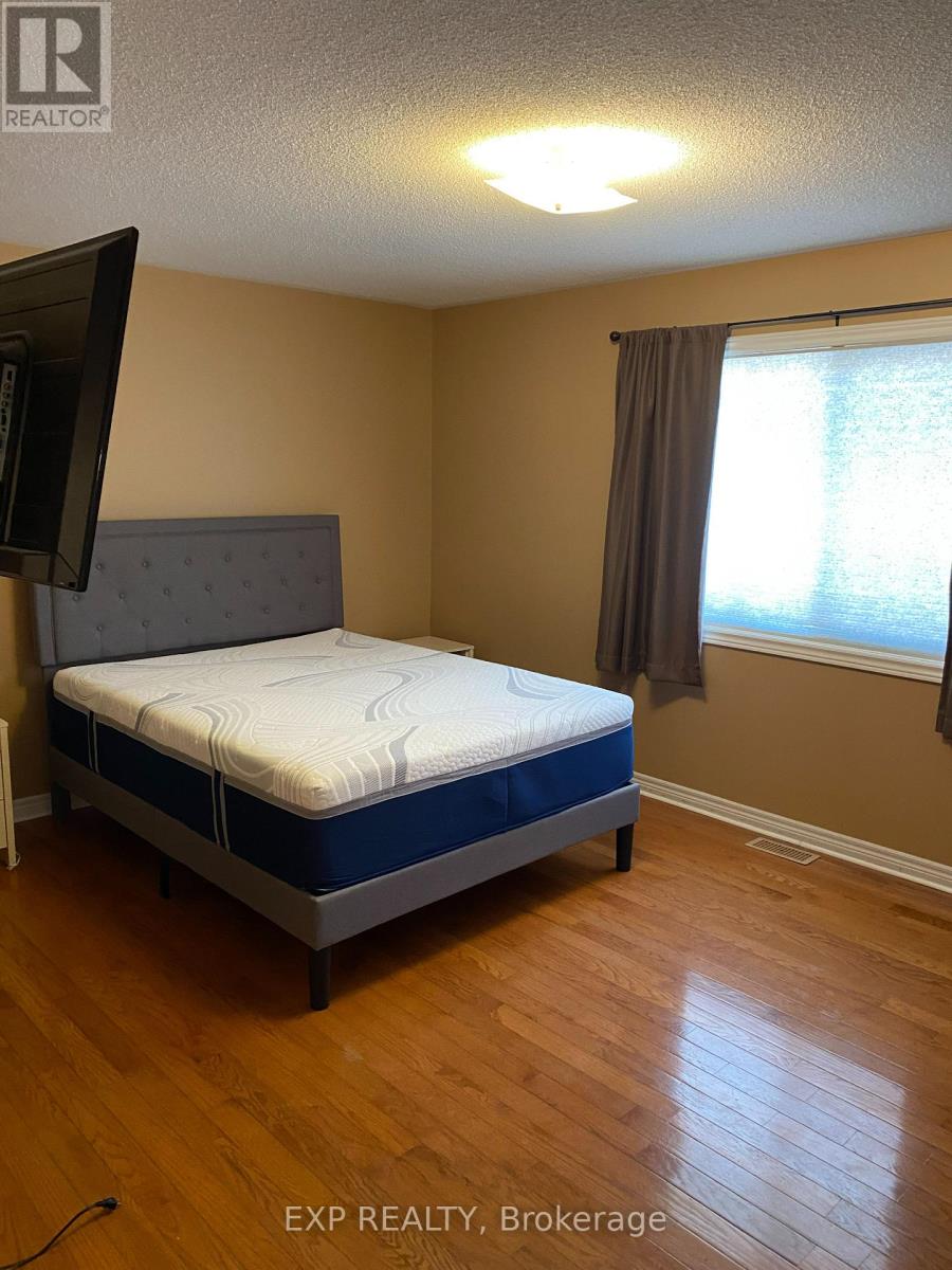 A bedroom with a bed, a television, and a window.