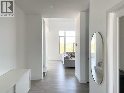 A modern living room with a grey sofa and a round mirror on the wall.