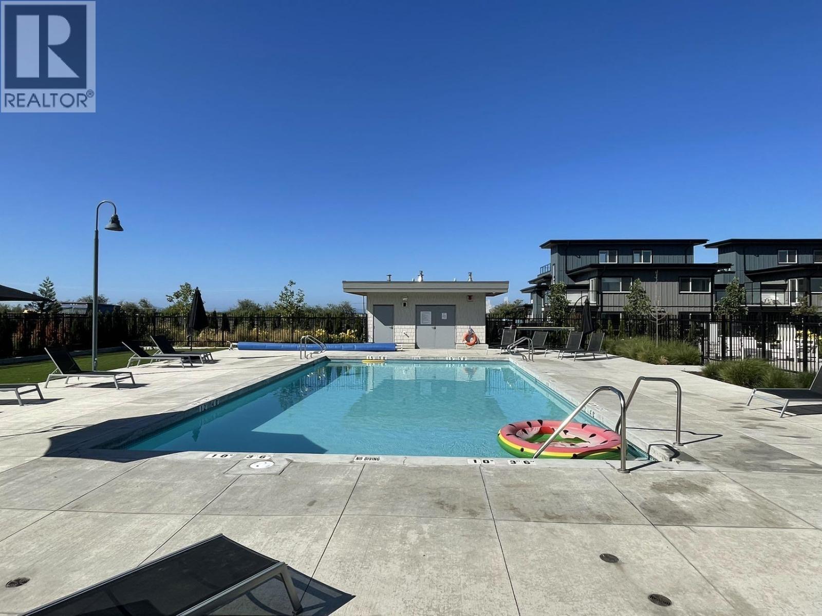A swimming pool with a slide and a watermelon on the ground.