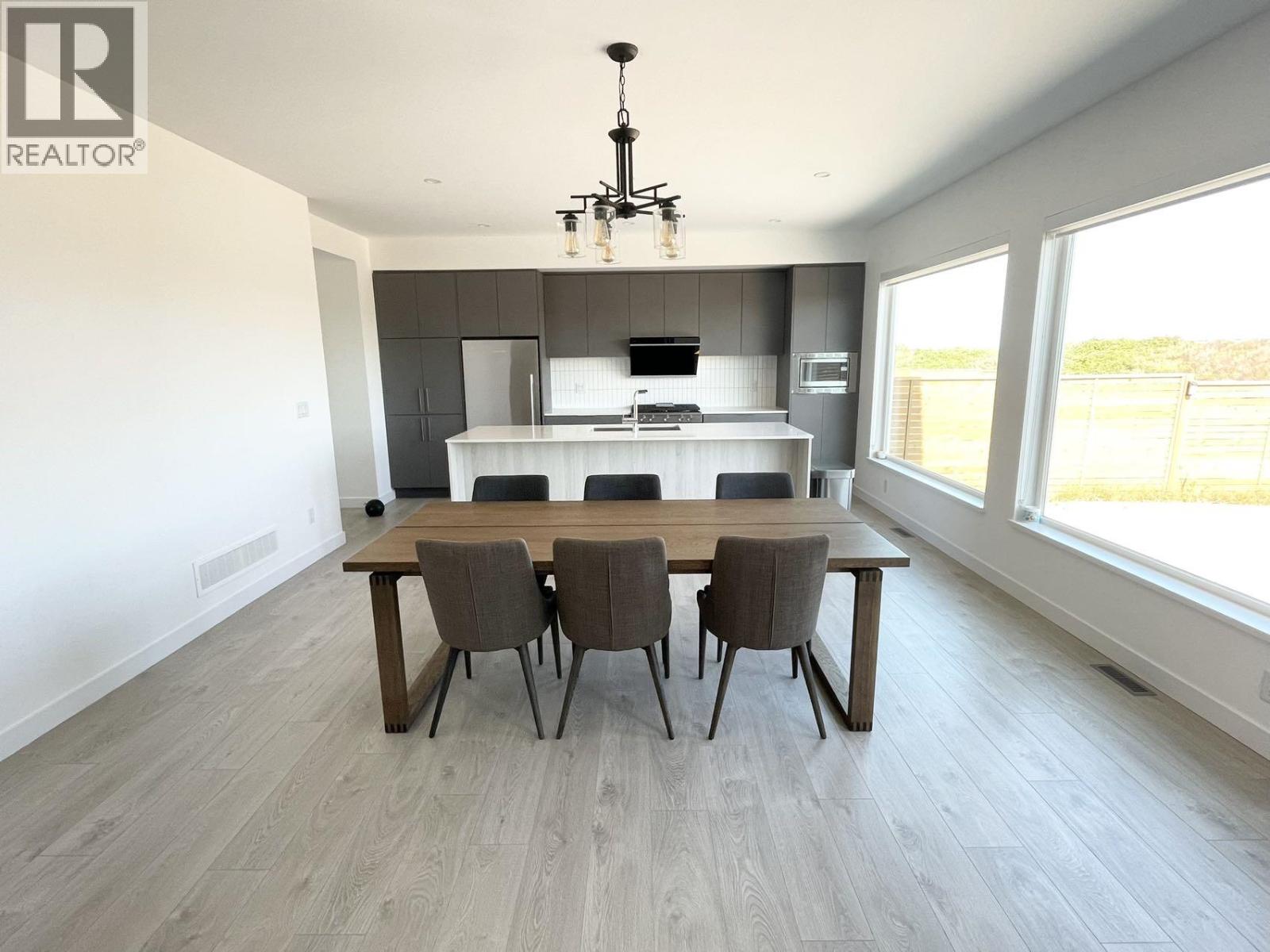 A modern dining room with a large table and chairs.