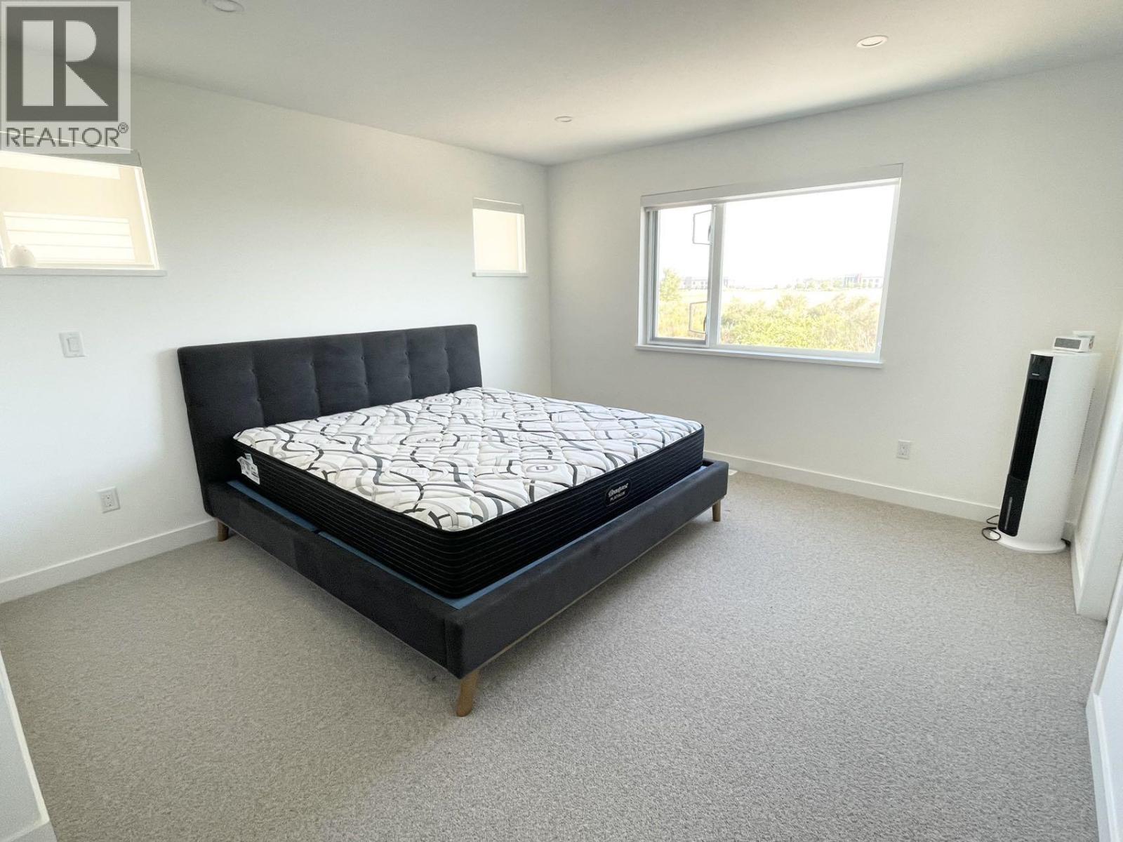 A bedroom with a large bed and a window.