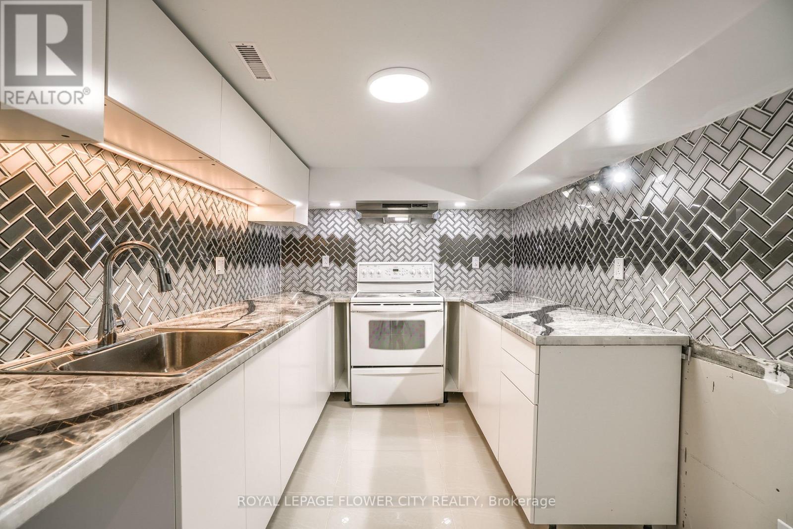 A kitchen with a white oven and sink.
