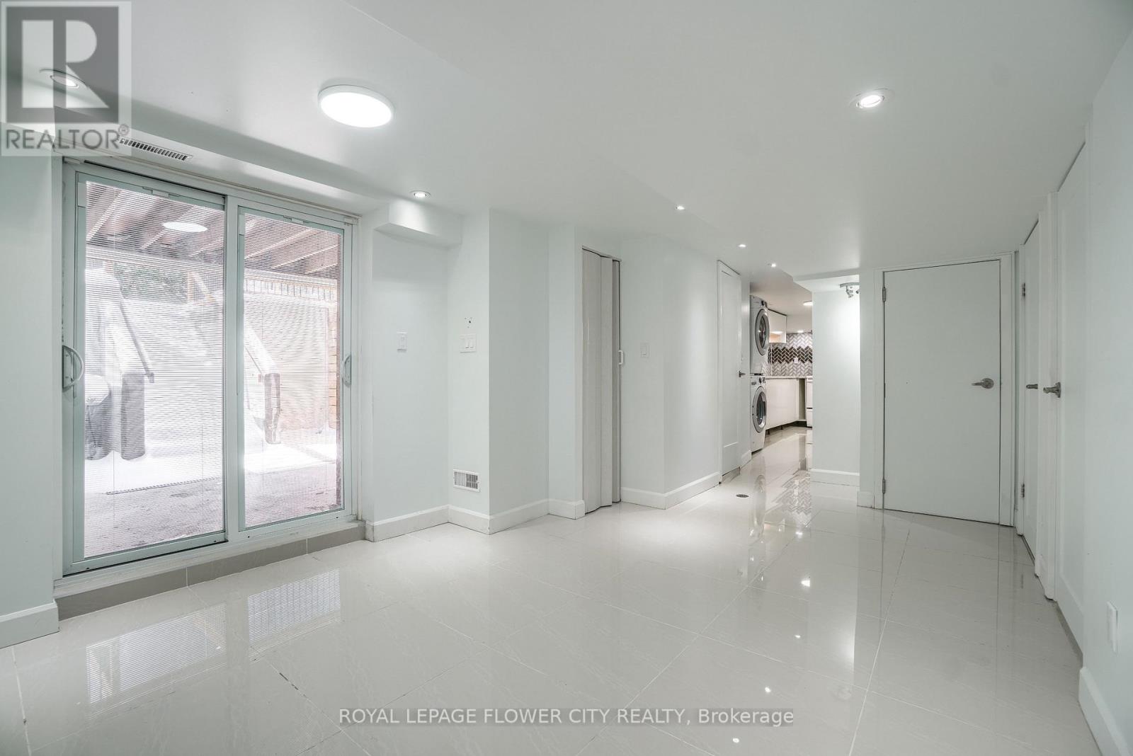 A white room with a sliding glass door and a hallway.