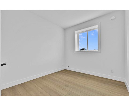 A room with a window and wooden flooring.