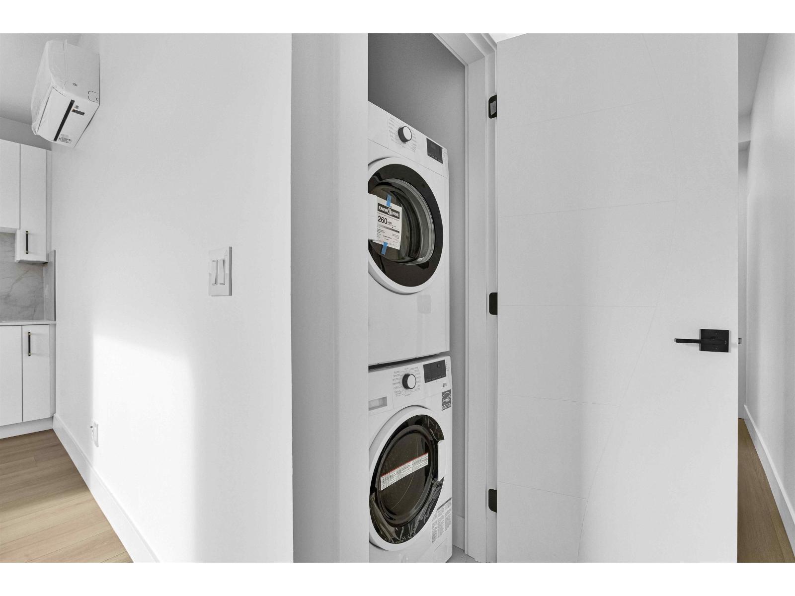 A washing machine is built into a wall in a modern laundry room.