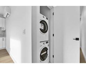 A washing machine is built into a wall in a modern laundry room.