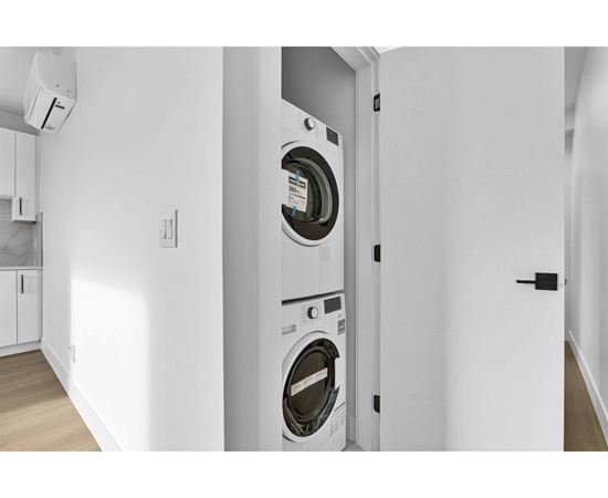 A washing machine is built into a wall in a modern laundry room.