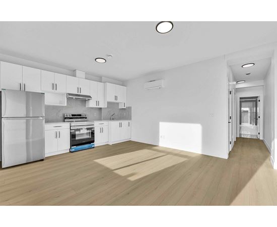 A modern kitchen with white cabinets and a wooden floor.