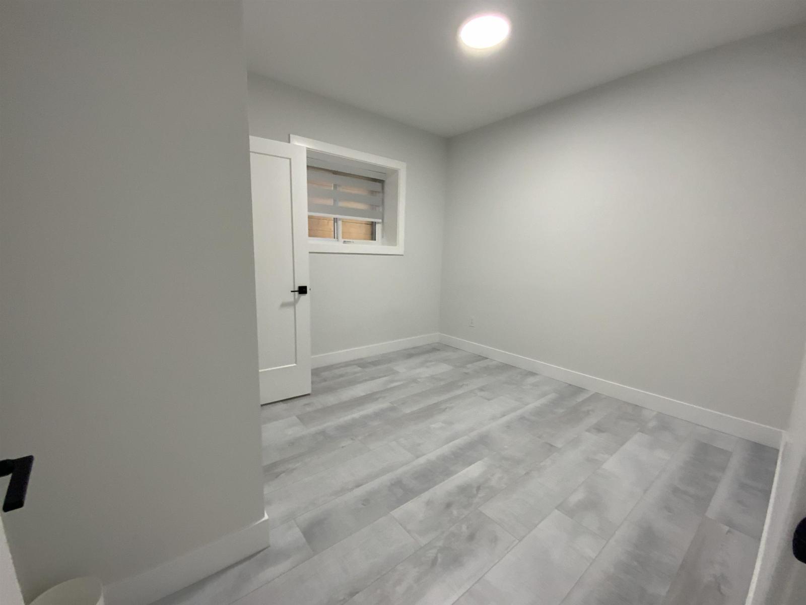 A room with a wooden floor and a white door.