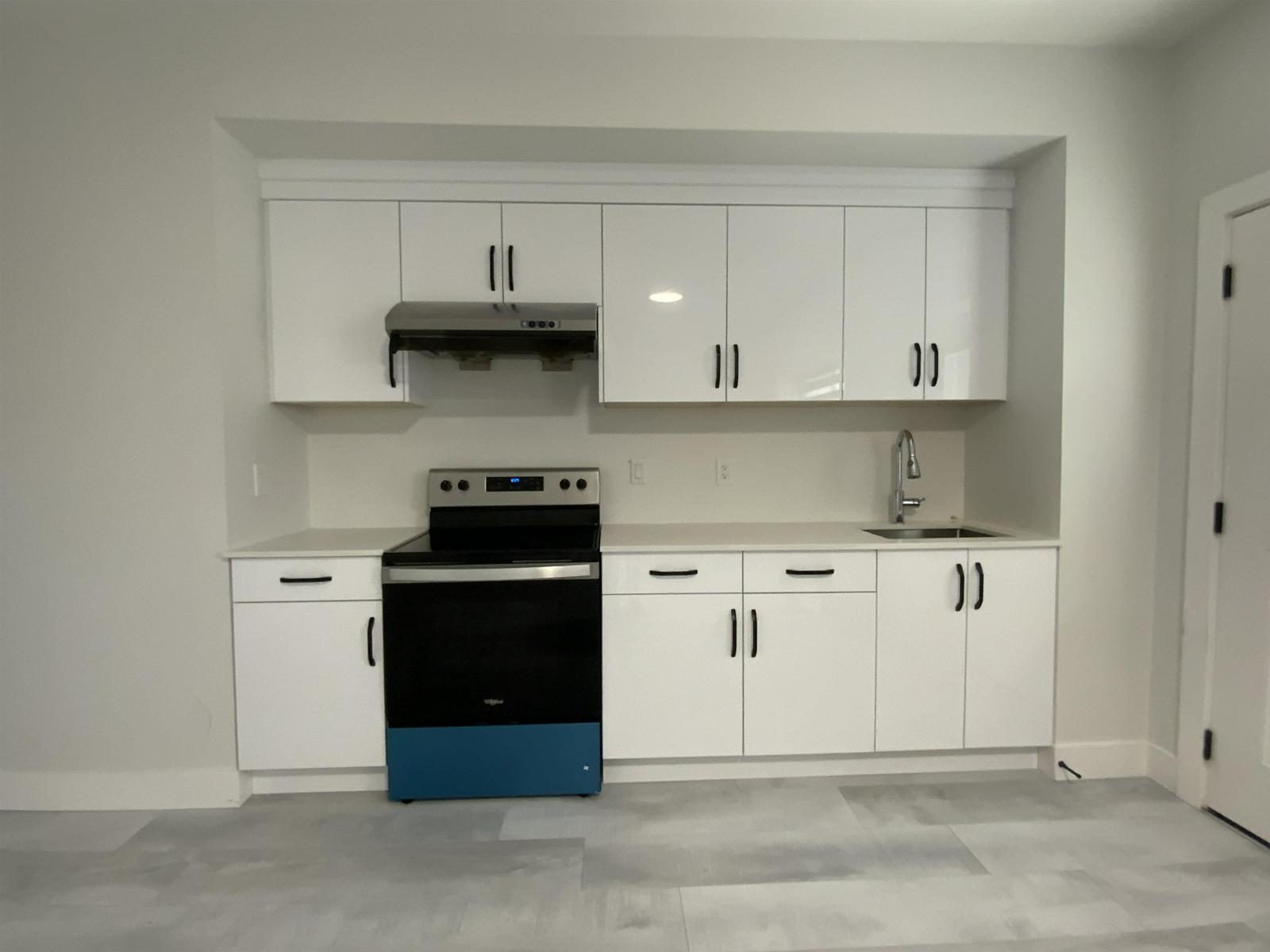 A kitchen with white cabinets and a blue oven.