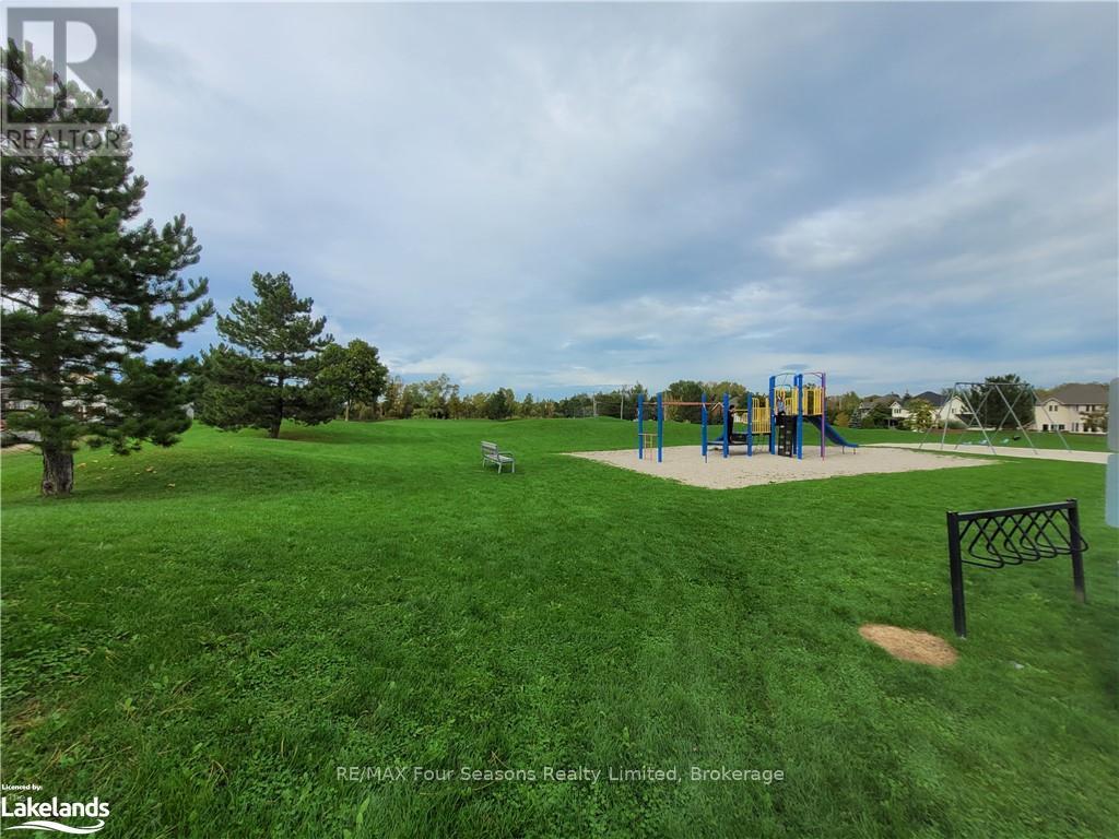 A playground with a slide and swings in a grassy area.